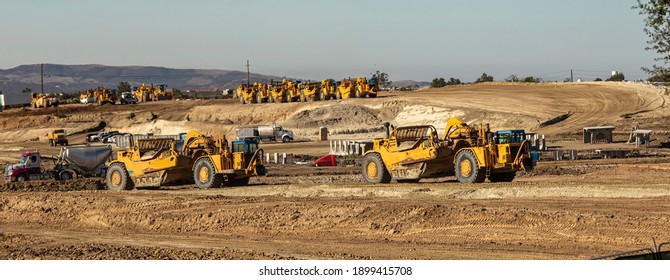 Earth Moving Equipment At A Construction Grading Site With Other Tractors Lined Up In The Background