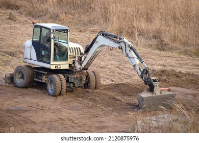 Earth Moving Tractor Preparing Place For Future House Foundation Construction. Leveling Soil For Building New Home