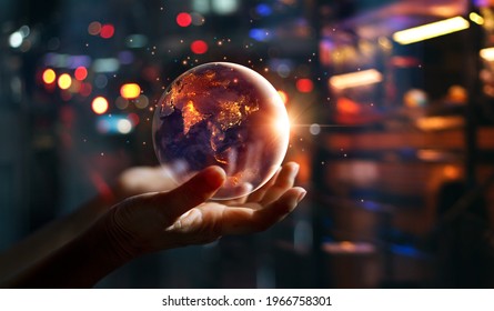 Earth at night was holding in hands on night city background , Energy saving, Earth day, Elements of this image furnished by NASA.