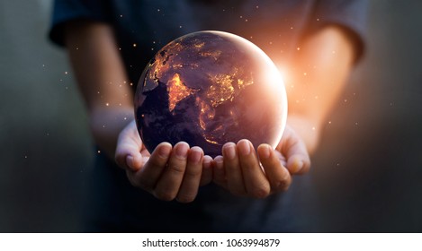Earth at night was holding in human hands. Earth day. Energy saving concept, Elements of this image furnished by NASA - Shutterstock ID 1063994879