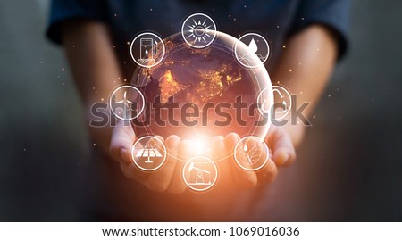 Earth at night was holding in human hands with energy resources icon. Earth day. Energy saving concept