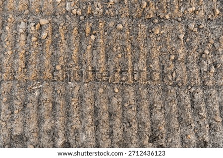 Earth Patterns: Top-Down View of the Texture and Furrows of a Tilled Field.