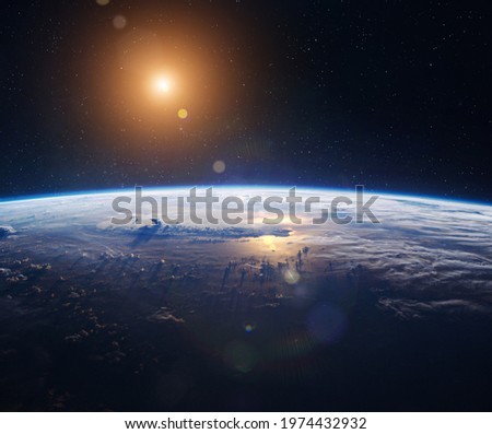 Earth planet surface in outer space with stars. Sun and stars. Space wallpaper. Horizon with clouds, blue sky and ocean. Elements of this image furnished by NASA