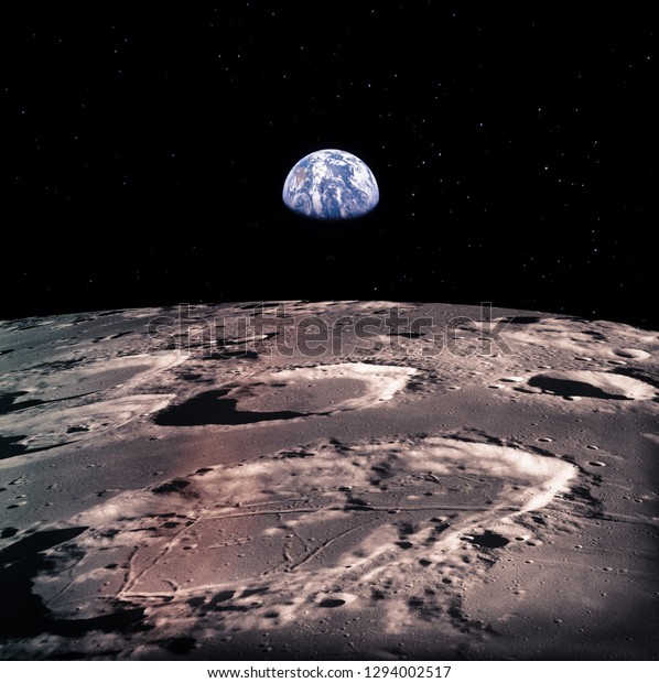 Earth rises above lunar\
horizon with huge meteor craters.  Elements of this image furnished\
by NASA.