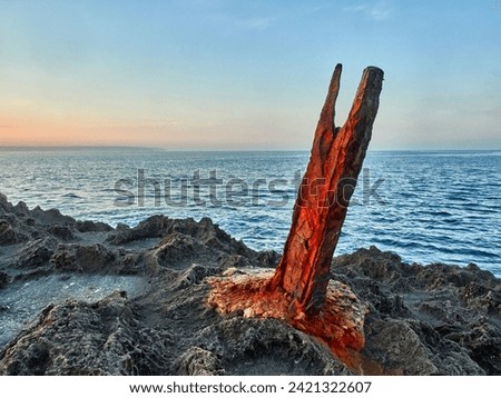 earth stabbed by a rusty iron beam