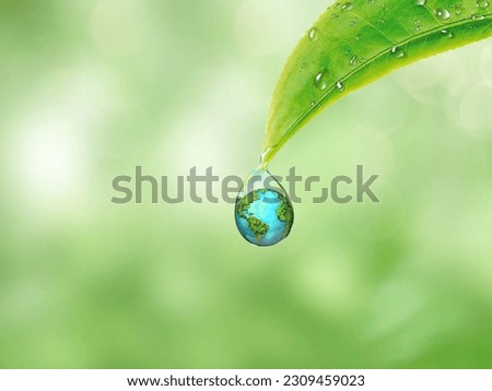 Earth in water drop reflection under green leaf, water and environment concept