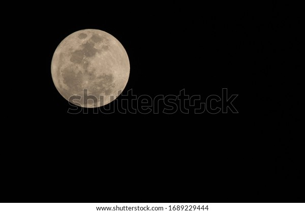 Earth\'s Moon Glowing On\
Black Background
