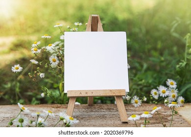 Easel on Lawn. Artistic Equipment on Nature. Empty artist canvas on wood easel. Summer Natur Background. Art picnic to enjoy in meadow - Powered by Shutterstock