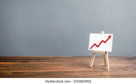 Easel With A Red Arrow Up. The Concept Of Success, Rapid Growth And Development. Business Planning And Revenue Analysis. Increase Efficiency, Productivity. Well-being And Prosperity, Promotion.