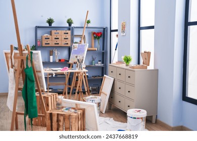 Easels, paintings, and art supplies create an inspiring artist's studio with abundant natural light. - Powered by Shutterstock