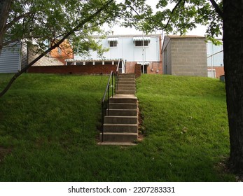 East Coast House Back Yard With Steps Leading Up Hill Through Green Grass