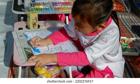 East Java, Indonesia - 13 Sept 2022. Kindergarten Coloring Contest In The Sub-district. This Student Wearing Pink And White Sports Uniform Looks Seriously Coloring. 