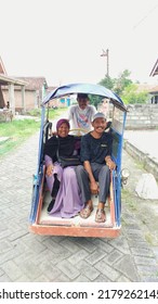 East Java, Indonesia- July 17, 2022: Two People Riding A Motorized Tricycle In The Village.