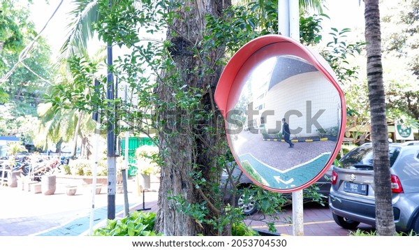 East Java, Indonesia, October 5, 2021. Convex\
mirrors are used to see the speed of vehicles from intersections or\
parking areas in buildings and installed attached to walls, pipes,\
or power poles