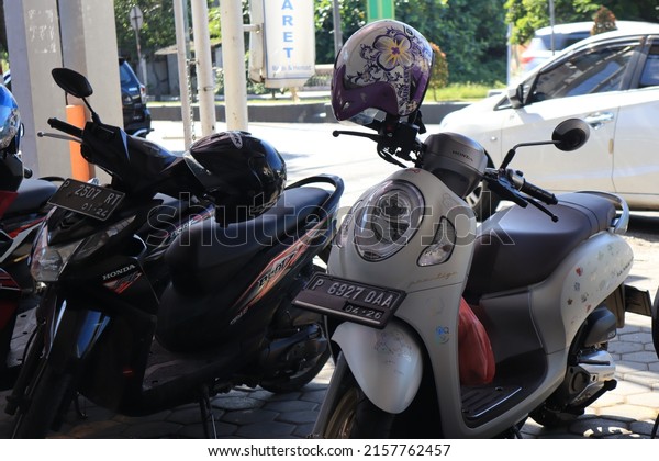 East java, May 2022. Motorcycles\
and helmets parked in the Indomart parking lot. a free motorbike\
parking space commonly used by local mini market\
customers.