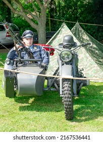 East Kirkby, Lincolnshire, UK – June 02 2022. World War 2 Re-enactment – Male Dressed Up As A German Officer In The Sidecar Of A Military Motorcycle