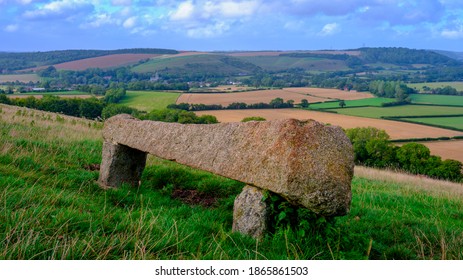 East Meon, UK - August 21, 2020:  A View Over The South Downs Village Of East Meon From Near Heyden Hill With A Stone Bench In The Foreground