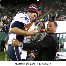 EAST RUTHERFORD, NJ - NOV 22: New England Patriots Quarterback Tom Brady (12) Hands A Turkey Leg To NBC Analyst Rodney Harrison After The Game Against The New York Jets On November 22, 2012.