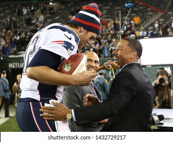 EAST RUTHERFORD, NJ - NOV 22: New England Patriots Quarterback Tom Brady (12) Hands A Turkey Leg To NBC Analyst Rodney Harrison After The Game Against The New York Jets On November 22, 2012.