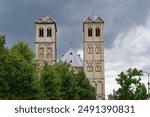 east side of the romanesque church St Gereon in Cologne with the two towers and the decagon in between in front of a dark cloudy sky