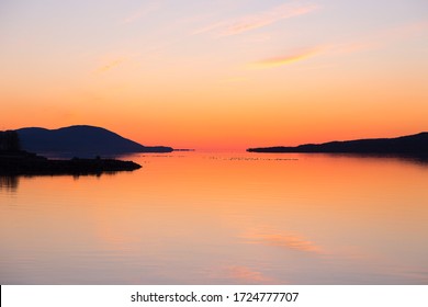 East View Of The St. Lawrence River Just Before Sunrise, With Cape Tourmente And The Island Of Orleans Seen In Silhouette From Sainte-Anne-de-Beaupré, Quebec, Canada