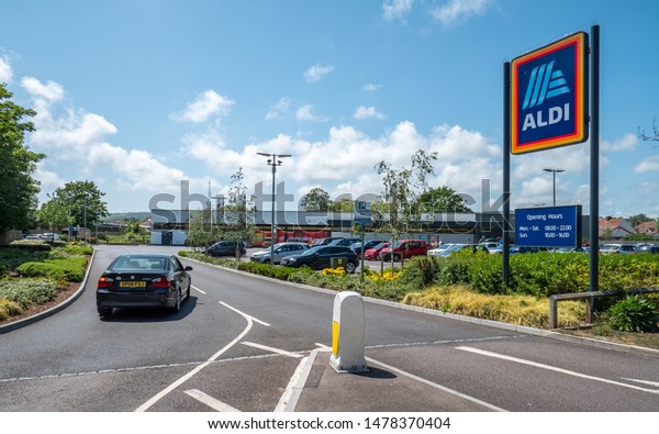 EASTBOURNE, UK - 3 JUNE 2019: Aldi\
Supermarket. A car entering the supermarket retailer, Aldi, on a\
bright day in the East Sussex town of Eastbourne,\
England.