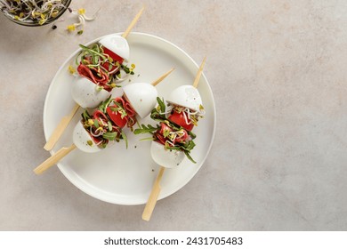 Easter appetizer; salad on skewers with boiled eggs, salami, cherry tomatoes, fresh leaf evegetables and sprouts - Powered by Shutterstock