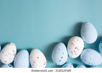 Easter background. Blue and white painted quail eggs on a blue background