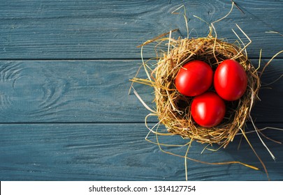 Easter background with bright red Easter eggs and spring flowers. Top view with copy space. 