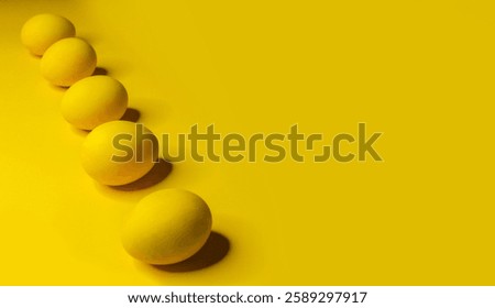 Easter background with bright yellow eggs. Easter composition. Top view of yellow Easter eggs on the yellow background.