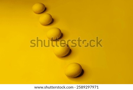 Easter background with bright yellow eggs. Easter composition. Top view of yellow Easter eggs on the yellow background.