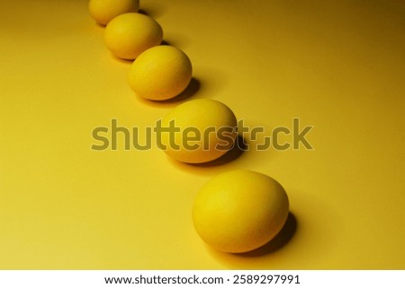 Easter background with bright yellow eggs. Easter composition. Top view of yellow Easter eggs on the yellow background.