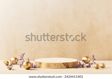 Easter background concept. Empty round wooden podium, golden easter eggs with spring flowers on a beige background