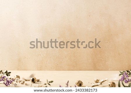 Easter background concept with quail eggs and spring flowers on a beige background