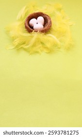 Easter background with Copy space for text. Flat lay.top view.Bird's nest with three white eggs nestled among yellow fluffy feathers on a light greenish yellow background