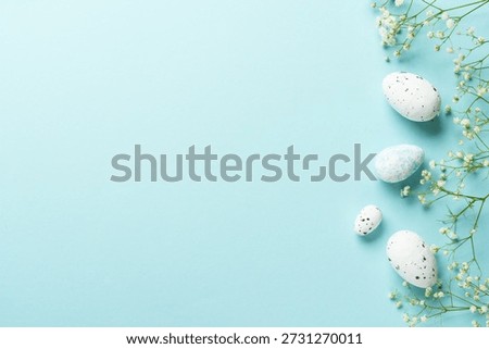 Easter background with eggs and flowers. Flat lay on blue background.