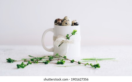 Easter background with Easter eggs in mug and spring flowers on rustic background. Copy space.