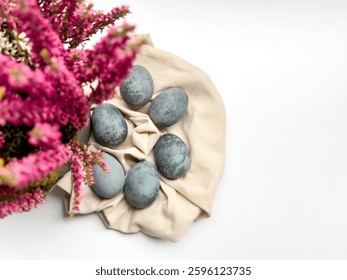 easter background with Easter eggs on beige linen fabric with colorful bouquet with empty space for text. minimalist ester background
