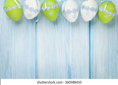 Easter background with eggs over blue wooden table. Top view with copy space
