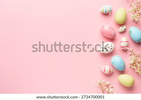 Easter background flat lay on pink. Colored eggs and flowers with copy space.