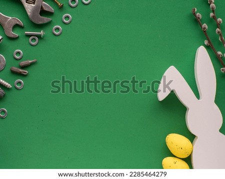 Easter background with hand tools, fasteners, fittings, yellow eggs and white rabbit. Easter card design with copy space. Easter and tools, worker concept.