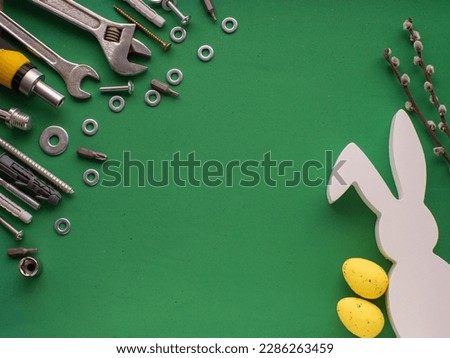 Easter background with hand tools, fasteners, fittings, yellow eggs and white rabbit. Easter card design with copy space. Easter and tools, worker concept.