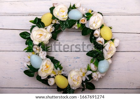 Easter background with spring easter eggs and flowers, wreath on door