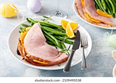 Easter Baked Ham Served On A Plate With Green Beans And Oranges