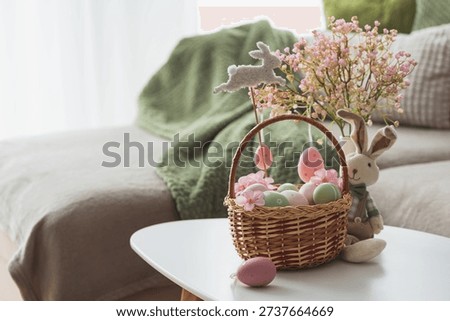 Easter Basket with Ester Eggs,  Plush Bunny and Spring Decor on White Table intoCozy Living Room
