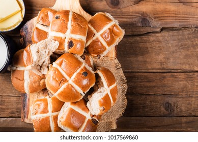 Easter Breakfast with Hot Cross Buns, served on Wooden Chopping Board, Dark wooden Rustic Background. Top View