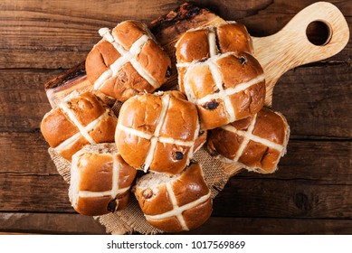 Easter Breakfast with Hot Cross Buns, served on Wooden Chopping Board, Dark wooden Rustic Background. Top View