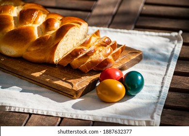 Easter breakfast, Striezel, yeast wreath, plait on a bread board, with colored eggs. plaited or braided, yeast bun