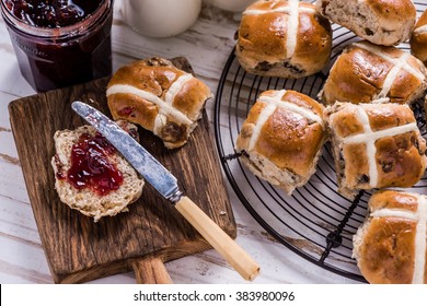 Easter breakfast with traditional hot cross bun and jam. From above on wooden table.