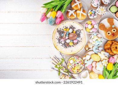 Easter brunch, breakfast food, Kids Easter party buffet. Various traditional Easter sweets, candy, pasties and baking - cross buns, cheesecake, chocolate eggs, pancakes, cupcakes, top view copy space - Shutterstock ID 2261922491